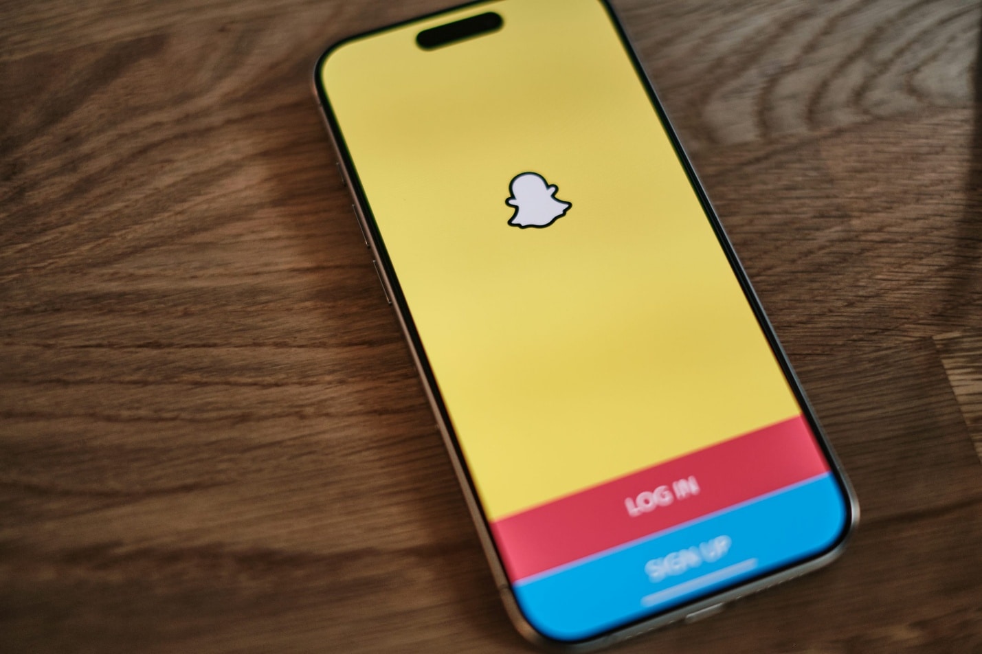 A yellow and blue iPhone sitting on top of a wooden table