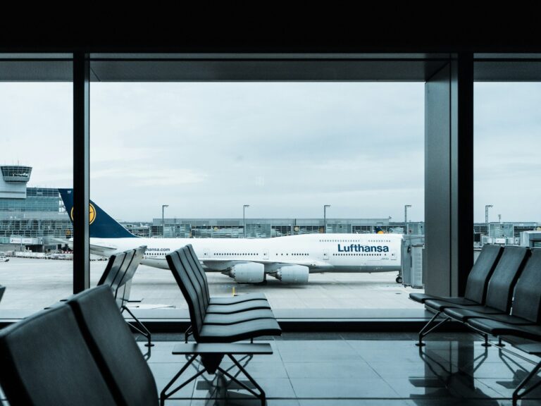 AI in Airports: The Successful Bid to Reduce Queue Times - SentiSight.ai A Lufthansa airplane seen through an airport windows. Image credit: Dennis Gecaj via Unsplash, free license